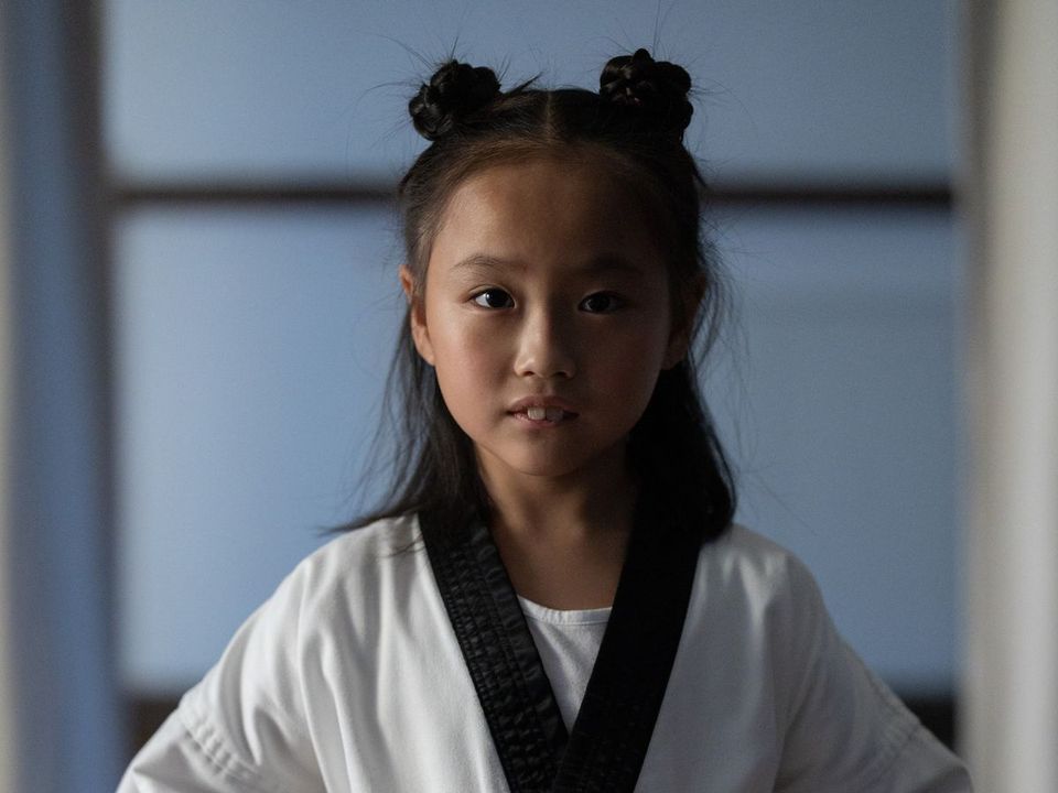Κορίτσι με στολή taekwondo δένει τη ζώνη του